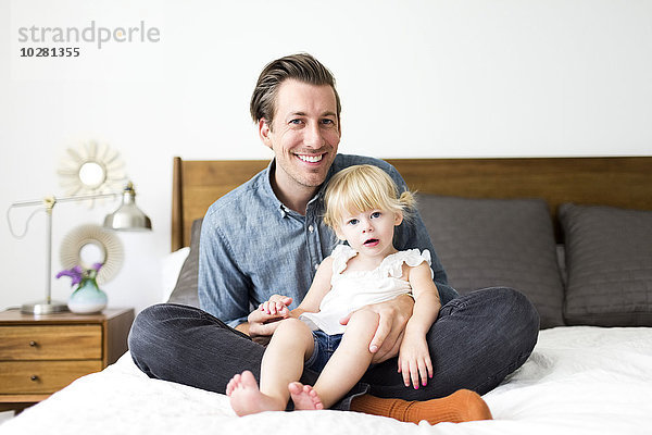 Porträt des Vaters mit Tochter (2-3) im Schlafzimmer