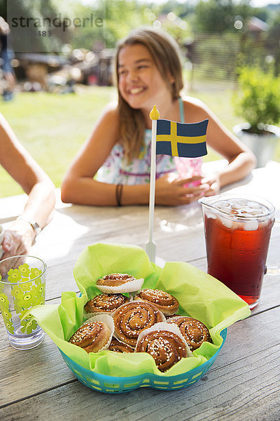 Zimtbrötchen mit schwedischer Flagge  Mädchen im Hintergrund