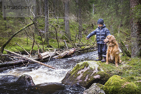 Junge mit Hund am Fluss