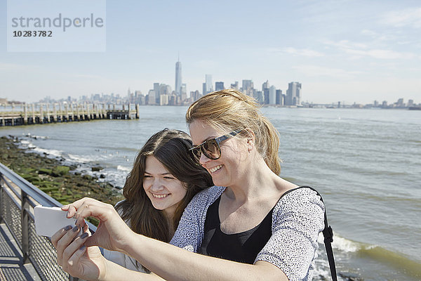 Junge Frauen machen ein Selfie mit Manhattan im Hintergrund  New York City  USA