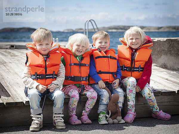 Lächelnde Kinder in Schwimmwesten