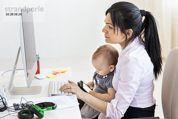 Geschäftsfrau mit kleinem Mädchen im Büro