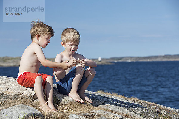 Jungen spielen auf dem Meer