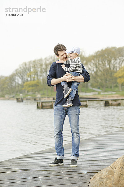 Vater mit Sohn auf dem Bootssteg
