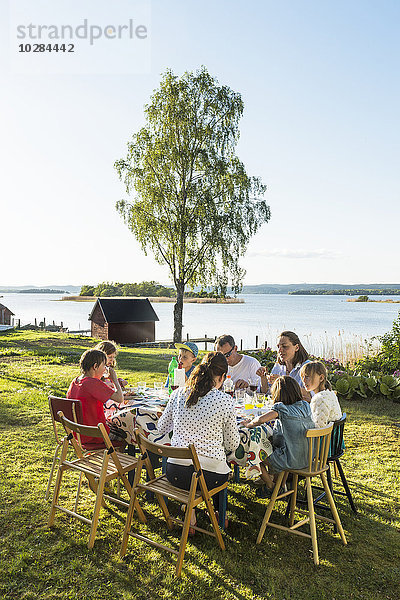 Familie beim Essen am See