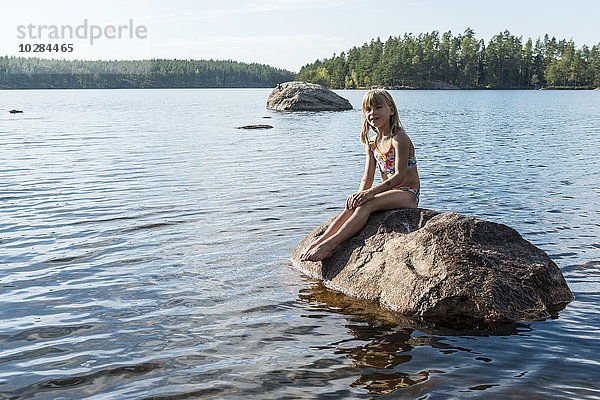 Mädchen auf Felsen im See
