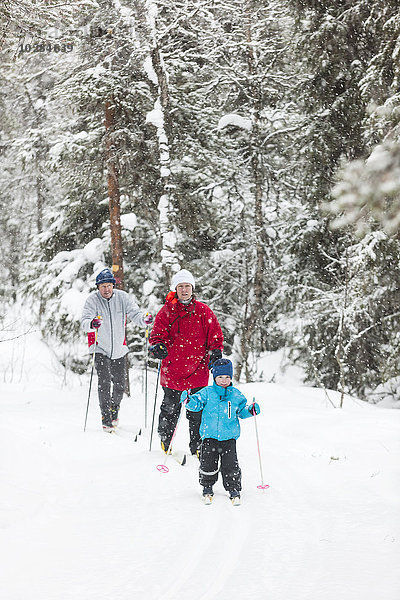 Junge beim Skifahren mit Eltern