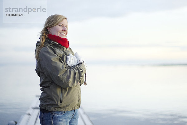 Lächelnde Frau mit Blick aufs Meer