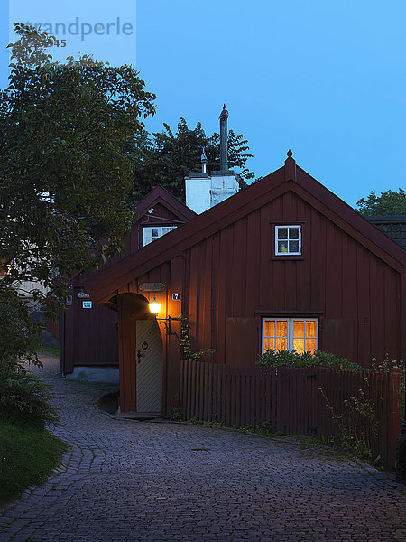 Beleuchtetes Holzhaus in der Abenddämmerung
