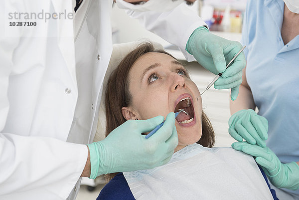 Zahnarzt bei der Untersuchung eines Patienten  München  Bayern  Deutschland