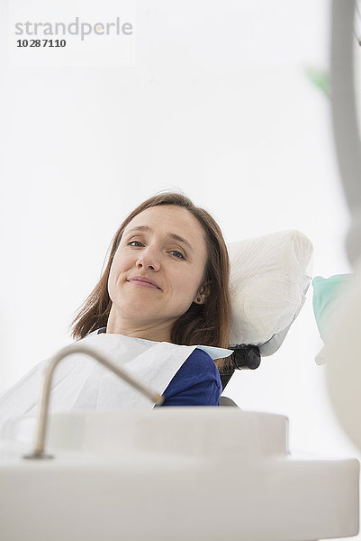 Glücklicher Patient auf einem Zahnarztstuhl in einer Zahnklinik  München  Bayern  Deutschland