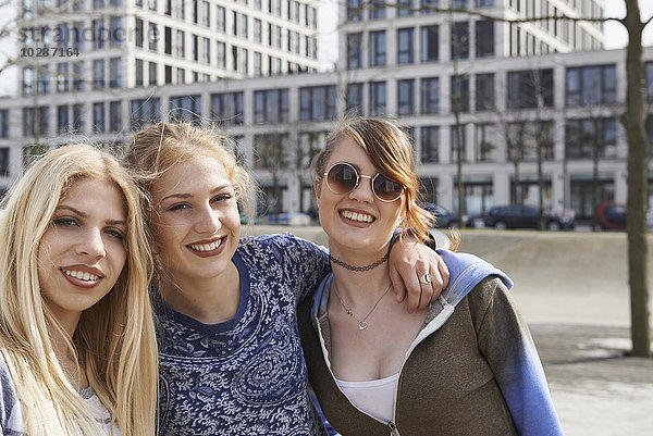 Drei lächelnde Freunde auf einem Spielplatz  München  Bayern  Deutschland