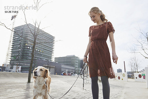 Junge Frau auf dem Spielplatz mit ihrem Hund  München  Bayern  Deutschland