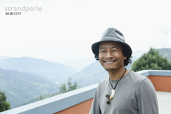 Porträt eines erwachsenen Mannes auf dem Dach und lächelnd  Nepal
