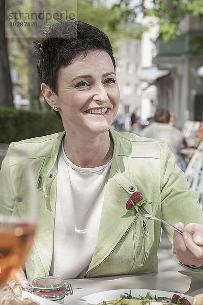 Ältere Frau beim Frühstück in einem Straßencafé  Bayern  Deutschland