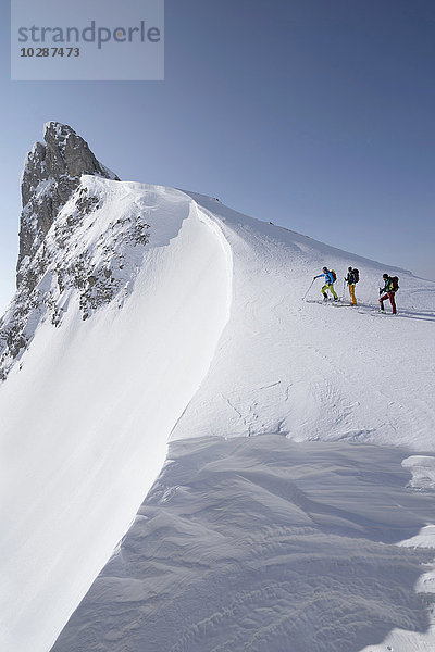 Skitourengeher beim Klettern auf einem verschneiten Gipfel  Tirol  Österreich