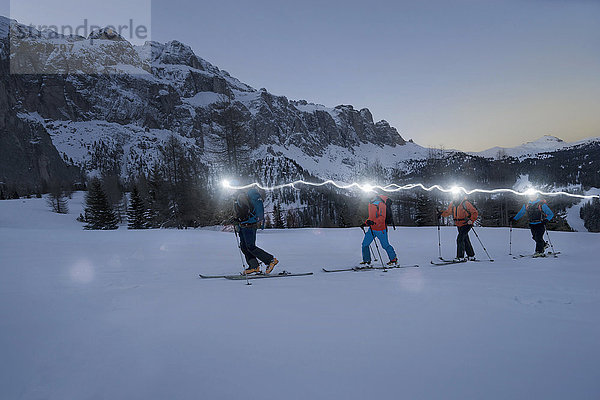 Skitourengeher beim Klettern auf einem verschneiten Berg mit Stirnlampen  Gröden  Trentino-Südtirol  Italien