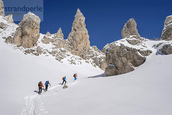 Skitourengeher beim Klettern auf einem verschneiten Gipfel  Gröden  Trentino-Südtirol  Italien