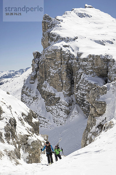 Skitourengeher beim Klettern auf einem verschneiten Berg  Gröden  Trentino-Südtirol  Italien