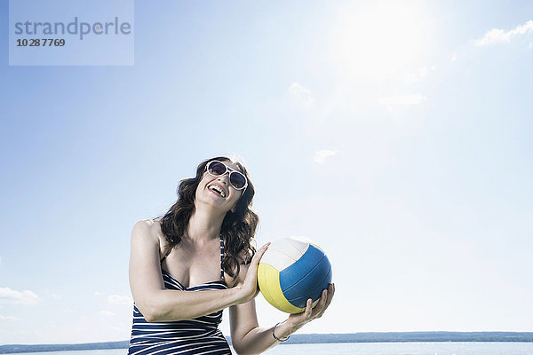 Ältere Frau spielt Volleyball am Strand  Bayern  Deutschland