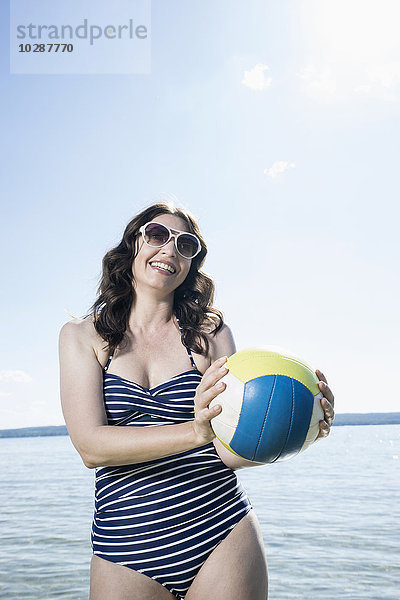 Ältere Frau spielt Volleyball am Strand  Bayern  Deutschland