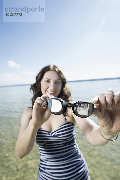 Ältere Frau mit Schwimmbrille und Lächeln am See  Bayern  Deutschland