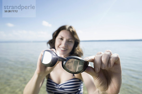 Ältere Frau mit Schwimmbrille und Lächeln am See  Bayern  Deutschland