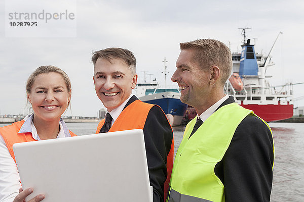 Porträt von Geschäftsleuten  die am Laptop im Hafen arbeiten  Hamburg  Deutschland