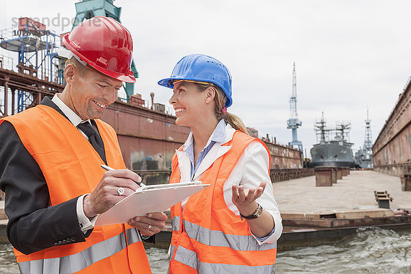 Hafenarbeiter erklären einem Manager während der Inspektion eines Industriehafens  Hamburg  Deutschland