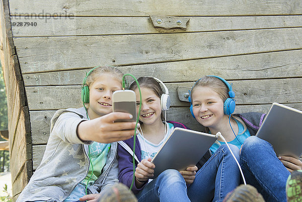 Drei Freunde sitzen auf einem Spielplatz und hören Musik  München  Bayern  Deutschland