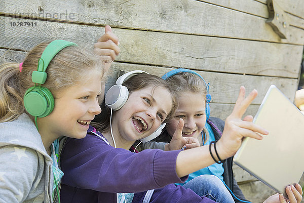 Drei Freunde sitzen auf einem Spielplatz und hören Musik  München  Bayern  Deutschland