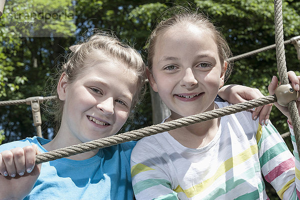 Lächelnde Mädchen auf einer Seilbrücke auf einem Spielplatz  München  Bayern  Deutschland