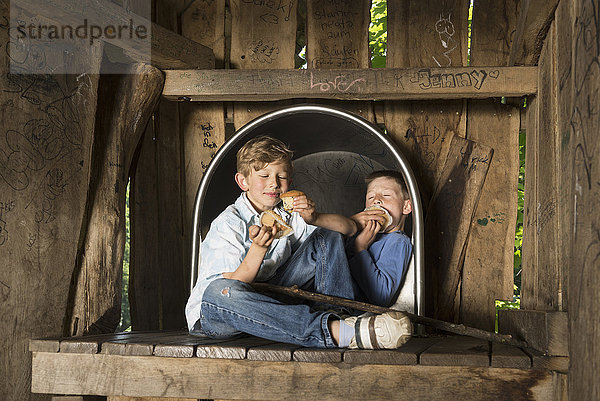 Zwei Jungen essen Muffins auf einem Spielplatz  München  Bayern  Deutschland