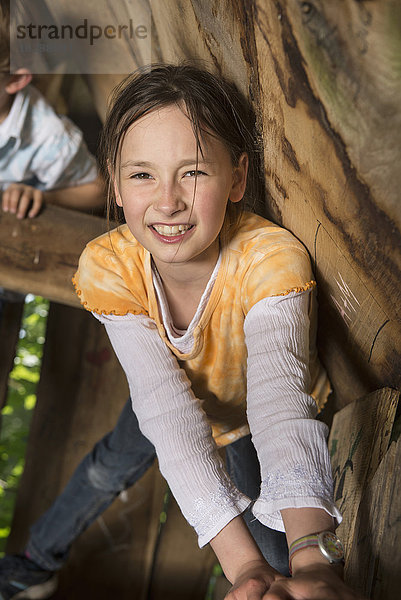 Mädchen klettert auf einem Baumhaus auf einem Spielplatz  München  Bayern  Deutschland