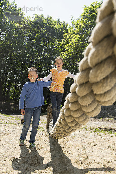 Junge und Mädchen spielen auf einem Spielplatz  München  Bayern  Deutschland