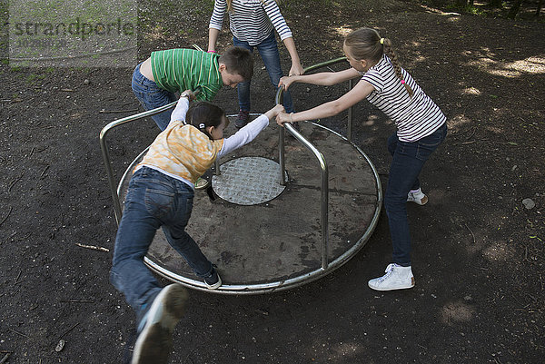 Kinder haben Spaß auf einem Karussell auf einem Spielplatz  München  Bayern  Deutschland