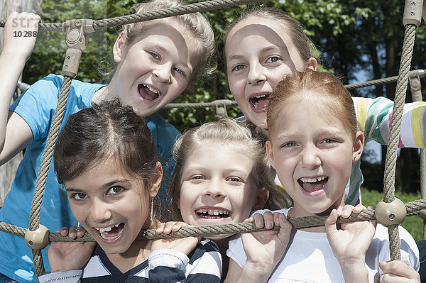 Lächelnde Mädchen auf einer Seilbrücke auf einem Spielplatz  München  Bayern  Deutschland