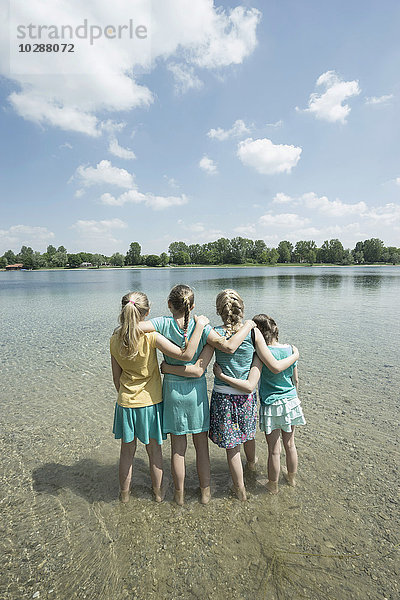 Gruppe von Freunden im See stehend  Bayern  Deutschland