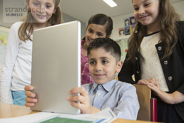 Schulkinder benutzen ein digitales Tablet im Klassenzimmer  München  Bayern  Deutschland