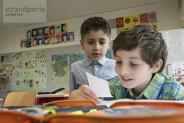 Schüler lesen eine Nachricht im Klassenzimmer  München  Bayern  Deutschland