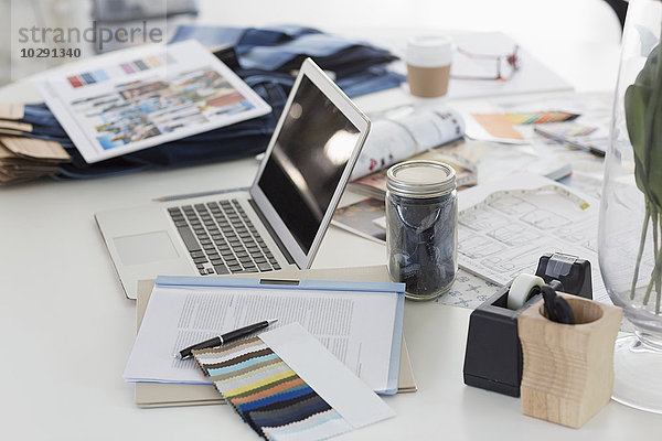 Laptop  Muster  Proofs und Papierkram auf dem Schreibtisch im Fashion Desk Office