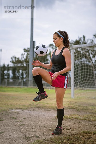 Fußballspieler hüpfender Ball auf dem Knie im Feld