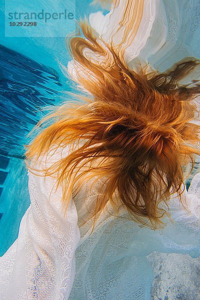 Junge rothaarige Frau unter Wasser  Draufsicht