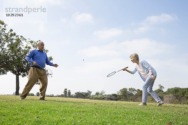 Seniorenpaar beim Badmintonspielen im Park