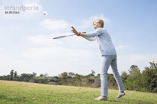 Seniorin spielt Badminton im Park