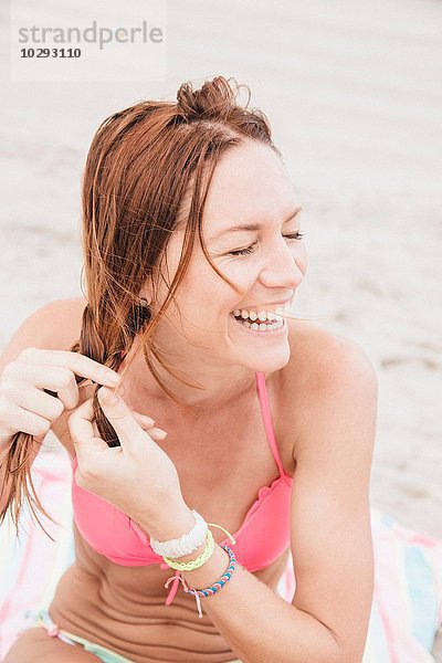 Mittlere erwachsene Frau am Strand  geflochtene Haare