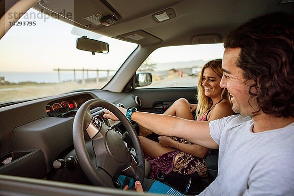 Paar im Auto auf der Reise  lächelnd