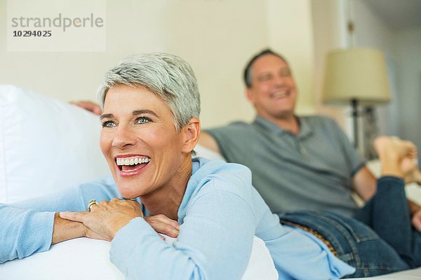 Reife Paare lachend und entspannend auf dem Sofa