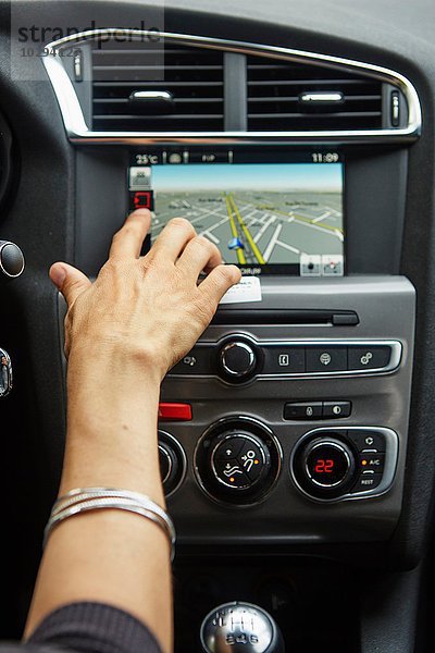 Frau sitzt im Auto  benutzt GPS  konzentriert sich auf die Hand.