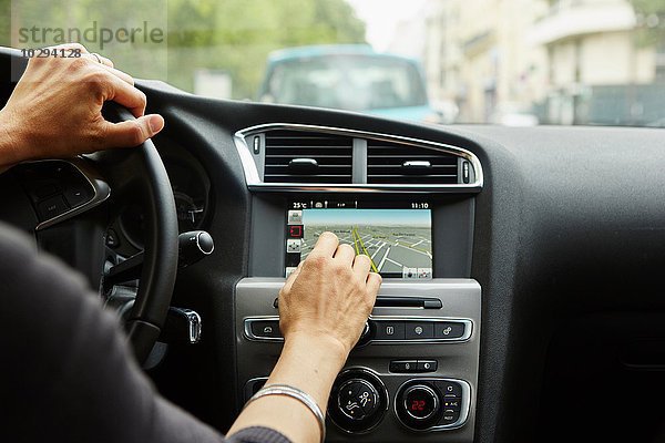 Frau sitzt im Auto  benutzt GPS  konzentriert sich auf die Hände.